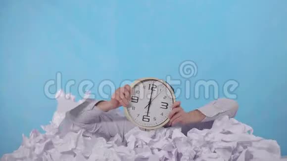 一名办公室工作人员带着一只手表从一大堆皱巴巴的纸里探出视频的预览图