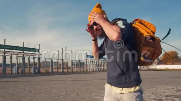 年轻英俊的野蛮胡须男背着背包跑秋日风格滑稽视频的预览图