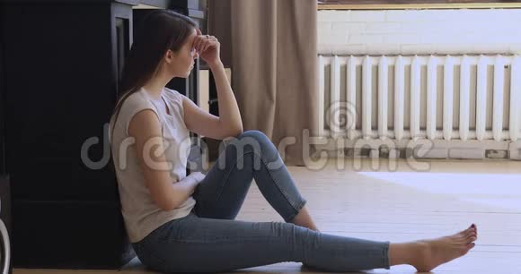 沮丧的年轻女子坐在地板上感到绝望视频的预览图
