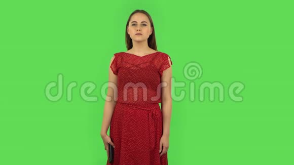 穿着红色衣服的温柔女孩愤怒地在手机上发短信绿色屏幕视频的预览图