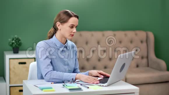 专注于商业女性在家庭办公室工作的笔记本电脑中型摄影机视频的预览图