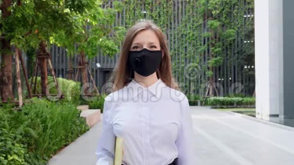 对中国冠状病毒的保护戴健康面具的商界女性视频的预览图