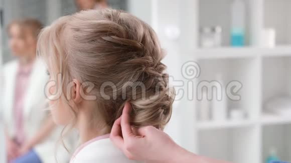 女造型师手应用发胶固定编织发型4k龙红相机视频的预览图