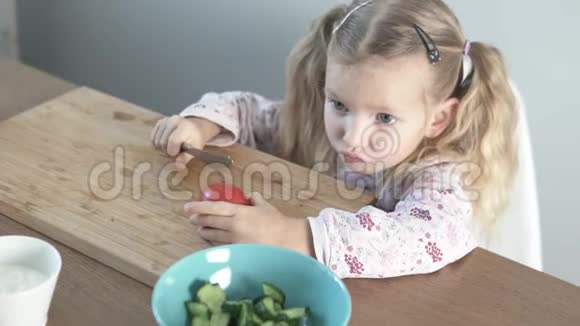 一个漂亮的小女孩切番茄做蔬菜沙拉视频的预览图