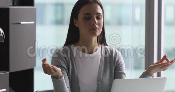 冷静的年轻女商人坐在桌子旁做着泥人的手势视频的预览图