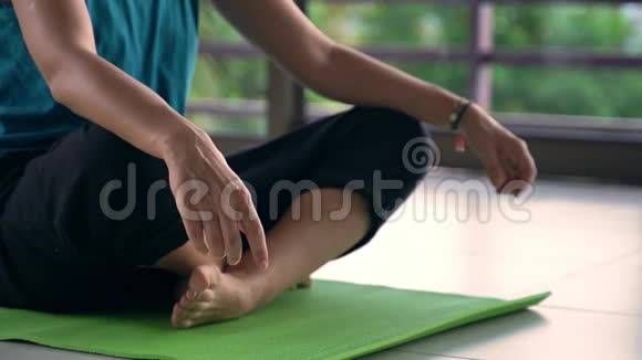 在瑜伽工作室里的瑜伽垫上放松的女性特写镜头视频的预览图