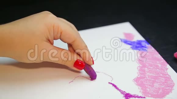 女人的手在白纸上用紫色的粉彩画夜空时间视频的预览图