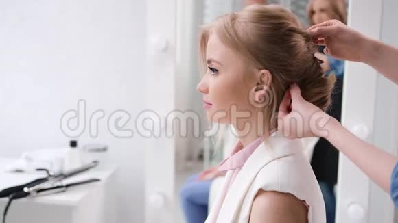 女模特坐在白色美容院内部创造发型4K红色摄像机拍摄视频的预览图