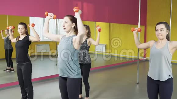 一群年轻女性在健身俱乐部和哑铃一起工作健康生活方式视频的预览图