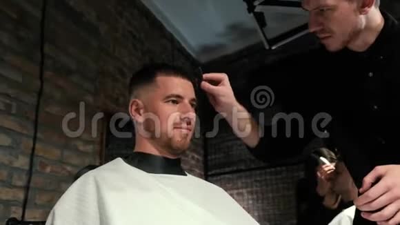 理发师用剪刀和梳子剪头发后面有理发店标志动作缓慢男人造男人的手视频的预览图