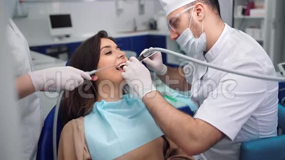 男性牙医统一检查和治疗女性病人的牙齿4K红色相机拍摄视频的预览图