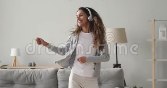 快乐精力充沛的混合种族女孩享受跳舞的喜爱音乐视频的预览图