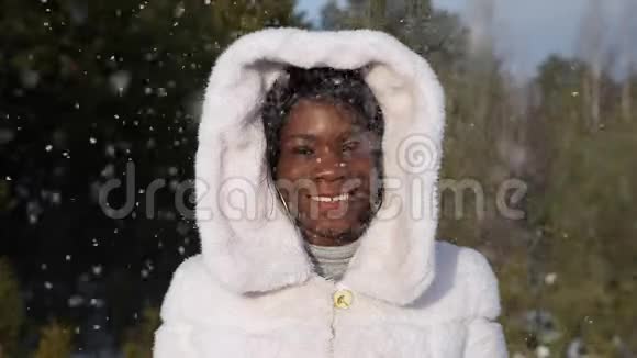 波光粼粼的雪地下非裔美国妇女摆姿势微笑视频的预览图