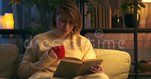 快乐的女人看书晚上喝咖啡视频的预览图