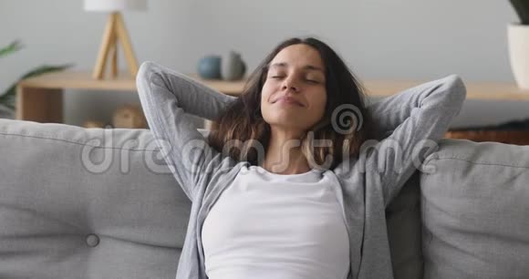 快乐宁静的千禧一代女人在舒适的沙发上放松视频的预览图