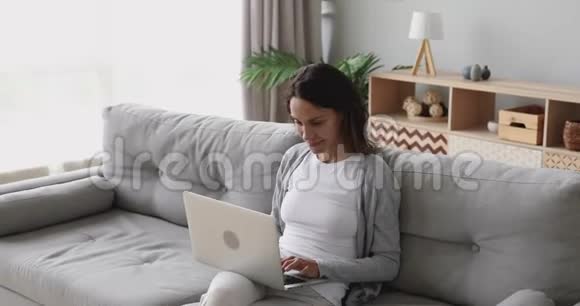 专注微笑的年轻混血女人在网上工作视频的预览图