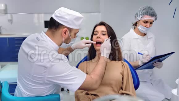 在牙医检查期间女性病人张口坐着拍摄红鸦4k影院视频的预览图