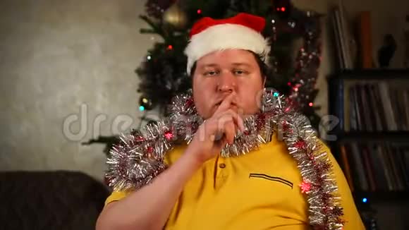 戴着圣诞帽的男人做着沉默的手势视频的预览图