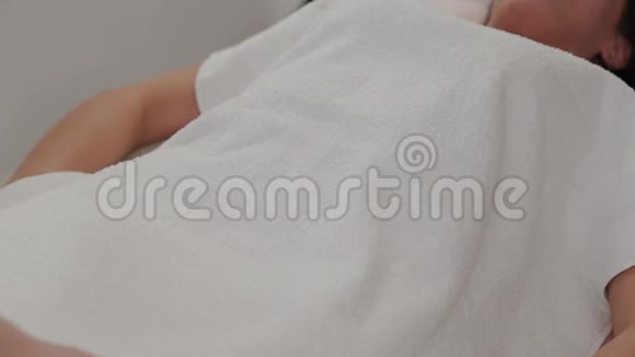 女按摩师在女孩的肚子上举起一条毛巾视频的预览图