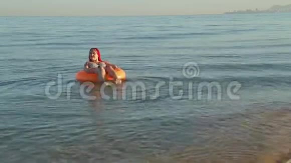 在游泳圈里一个穿着泳衣的女人在海浪上摇摆视频的预览图