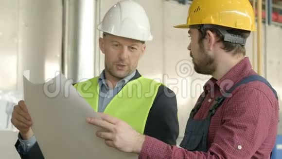 两名工人在工厂车间带蓝图视频的预览图