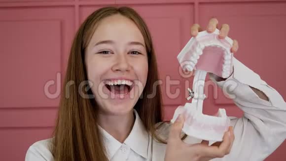 一个年轻女孩微笑和笑的肖像点击她的下巴植入物视频的预览图