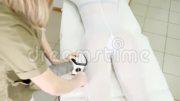 穿绿色外套的女士在沙龙病人腿上做脂肪分析视频的预览图