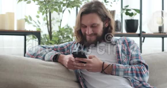 男人在家里用智能手机吃爆米花视频的预览图