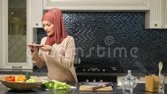穆斯林妇女主持烹饪博客告诉用户食谱视频的预览图