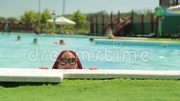 度假时一位满头红发的快乐女子游到游泳池乐园休息视频的预览图