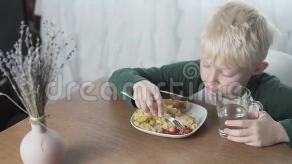 漂亮的金发男孩在家吃饭视频的预览图
