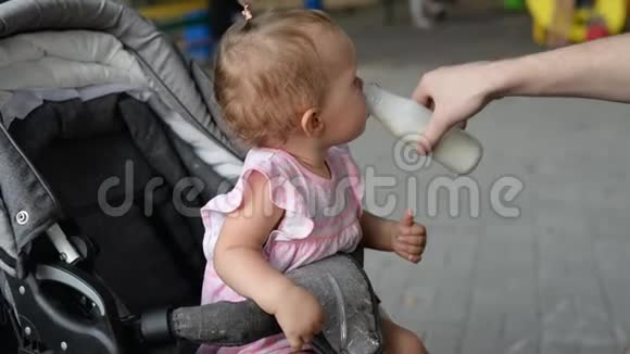 可爱的女婴在父亲手里喝牛奶视频的预览图
