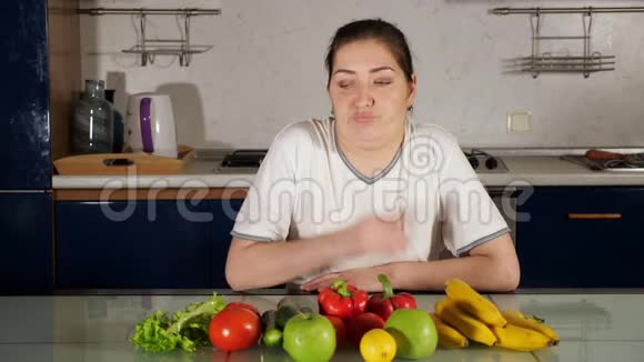 女人端着有机食物坐在桌子上吃新鲜的生菜视频的预览图