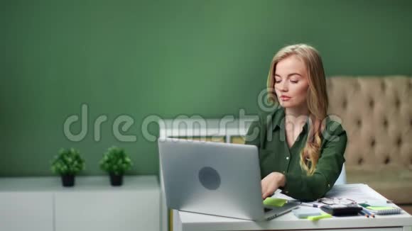 专注于在笔记本电脑上远程工作的年轻商务女性中型摄影机视频的预览图
