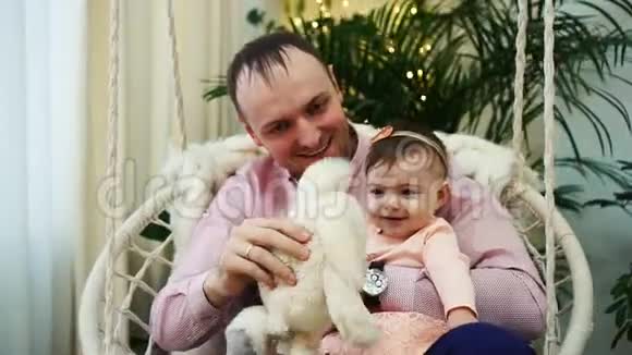 快乐的年轻父亲和宝贝女儿玩爸爸和宝贝女孩玩毛绒玩具视频的预览图