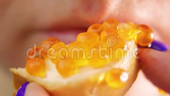 女性的嘴咬从一个三明治与鱼子酱和咀嚼视频的预览图