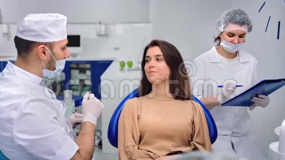 男性医生穿白色无菌制服与女性患者交谈4k龙红相机视频的预览图