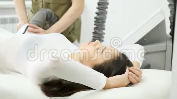 漂亮的黑发女人躺在沙发治疗师做脂肪分析视频的预览图