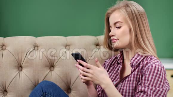 在家休息时使用电话的攻击性女性打字信息中型近距离拍摄4k红色相机视频的预览图