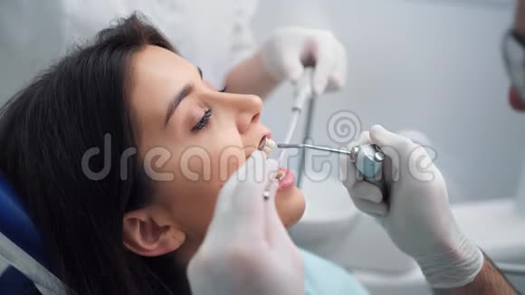 在牙科诊所治疗牙齿时关闭女性患者的面部4K红色相机拍摄视频的预览图