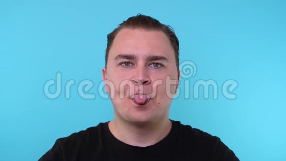 白种人的舌头伸出在蓝色背景上视频的预览图
