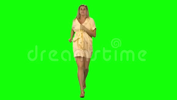 晒黑的金发女人跑着挥手然后停在绿色的屏幕上前景视频的预览图