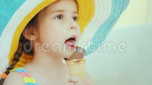 一个扎着辫子的可爱女孩正在吃冰淇淋坐在甲板椅上休息的海洋概念视频的预览图
