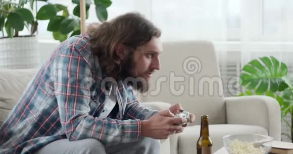 男人在家里玩电子游戏庆祝胜利视频的预览图