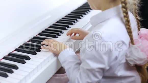 小女孩用白色钢琴演奏古典音乐视频的预览图