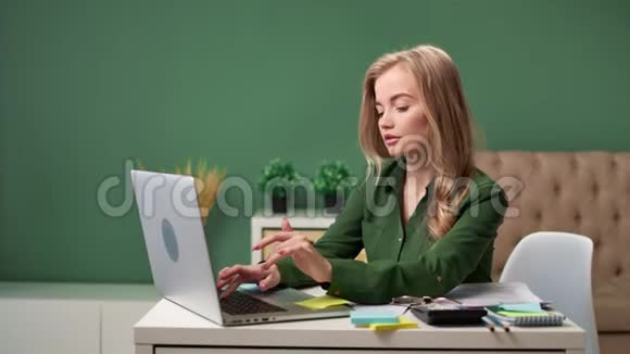 自信的年轻商务女性使用笔记本电脑在家庭办公室工作中型摄影机视频的预览图