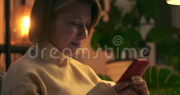 快乐的女人晚上用手机视频的预览图