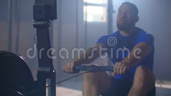 慢动作一名男子赛艇运动员在赛艇机上的健身室里训练视频的预览图