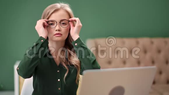漂亮的商务女性在现代办公桌上摆着眼镜中型摄影机视频的预览图