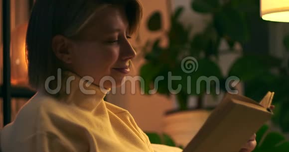 快乐的女人晚上看书视频的预览图